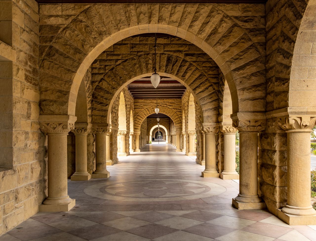 Elegant stone archway corridor at Stanford University, a perfect blend of history and architecture.